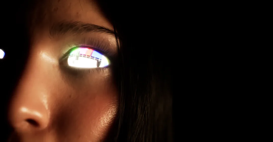 Extreme close-up of a woman's eye in darkness, reflecting a television test pattern